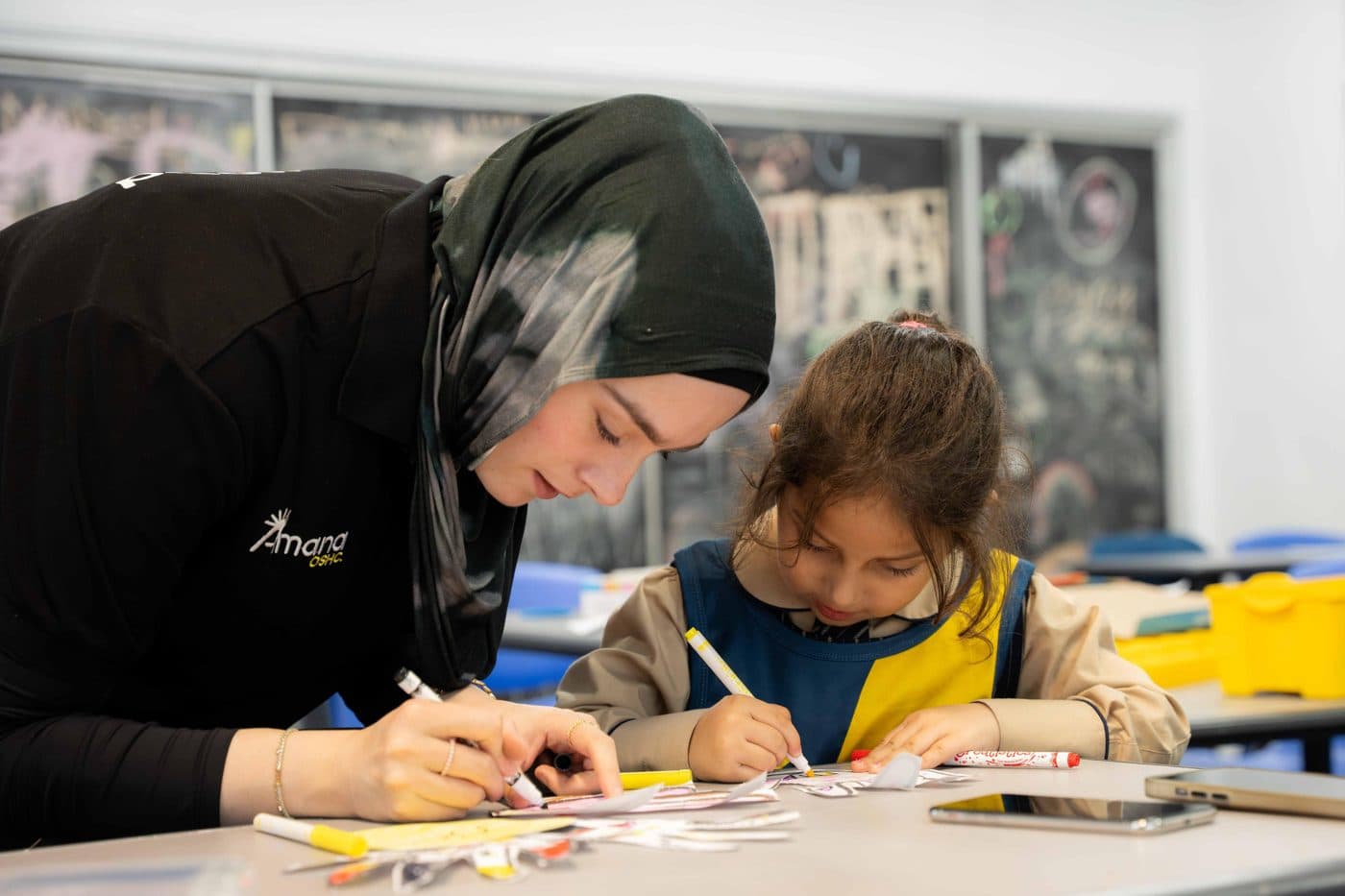 An Amana OSHC educator supporting a child during an afternoon activity