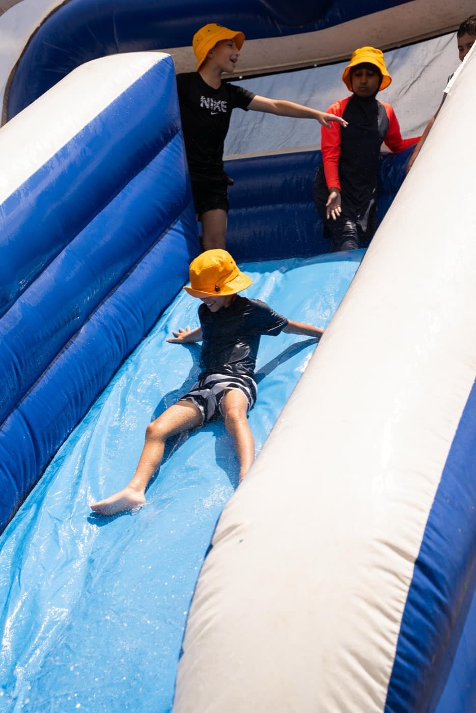 Children on a giant inflatable waterslide during Holiday Quest